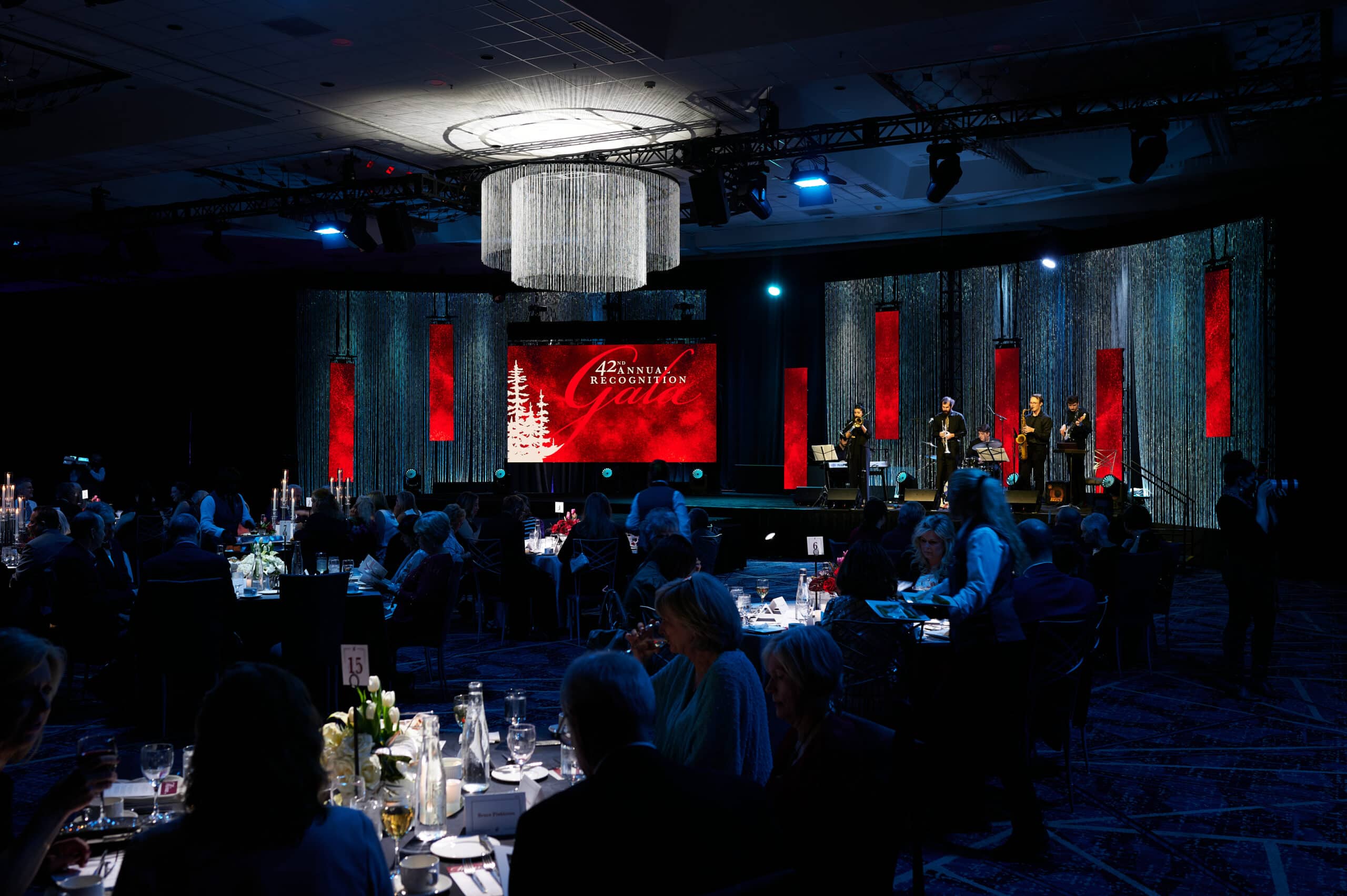 Wide shot of the stage and people enjoying dinner at the WSU 42nd Annual Recognition Gala