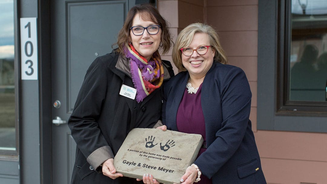 Image of Gayle Meyer, CFO, MeyerPro, and Derenda Schubert, Executive Director of Bridge Meadows holding a plaque together