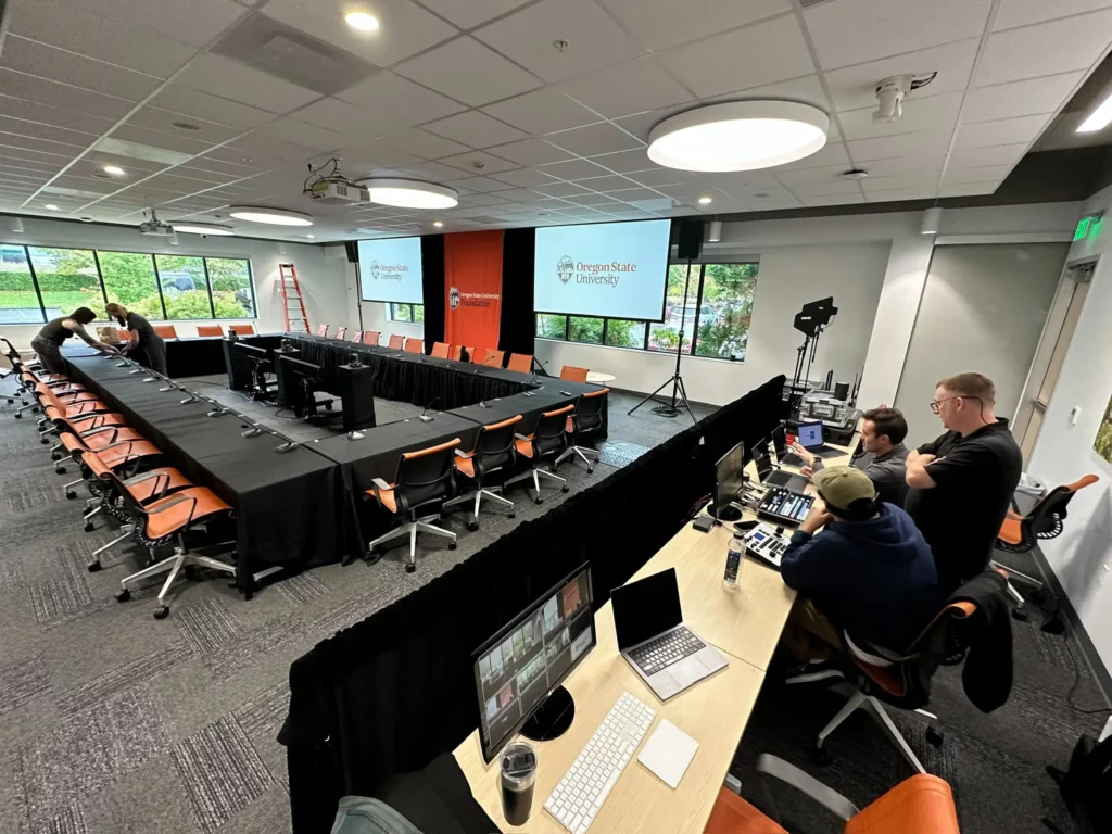 AV setup for a corporate breakout room with microphones, projection screens, and technical support