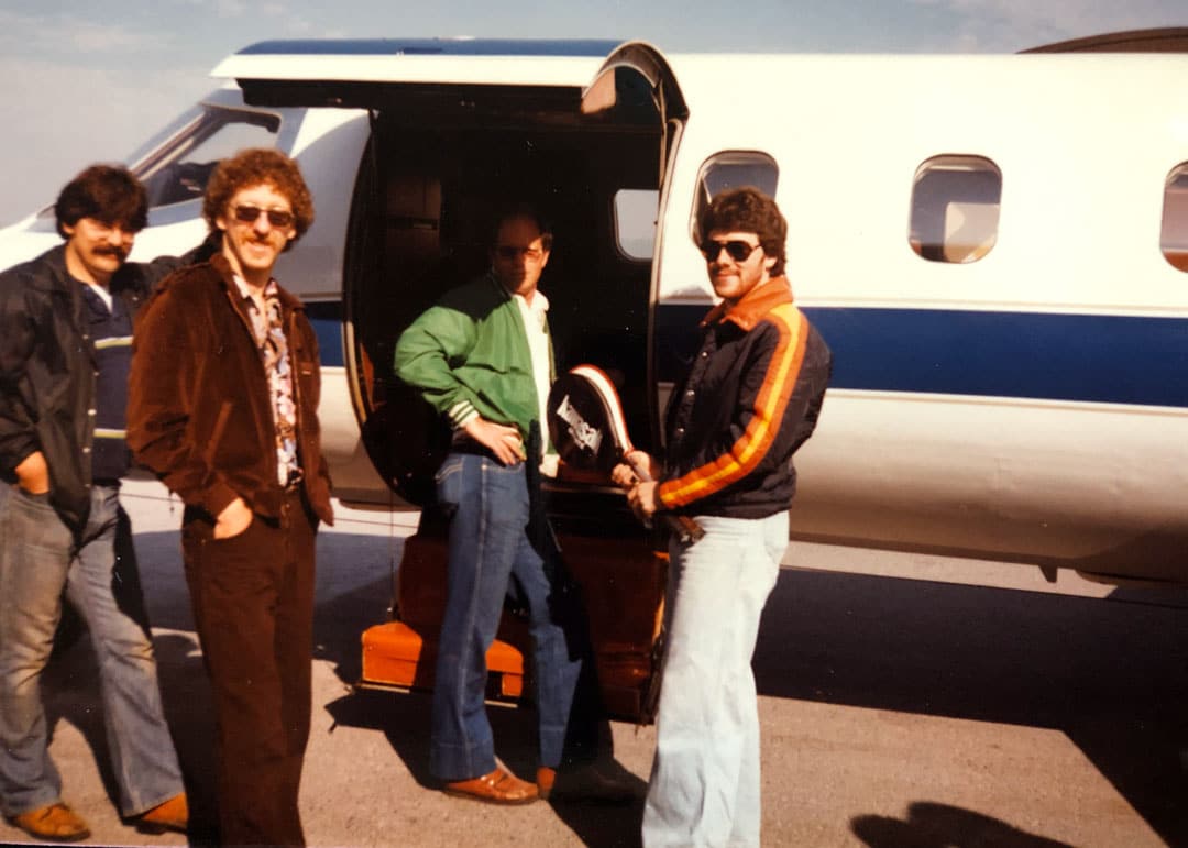 Photo from many years ago of the team getting ready to fly off in a small plane