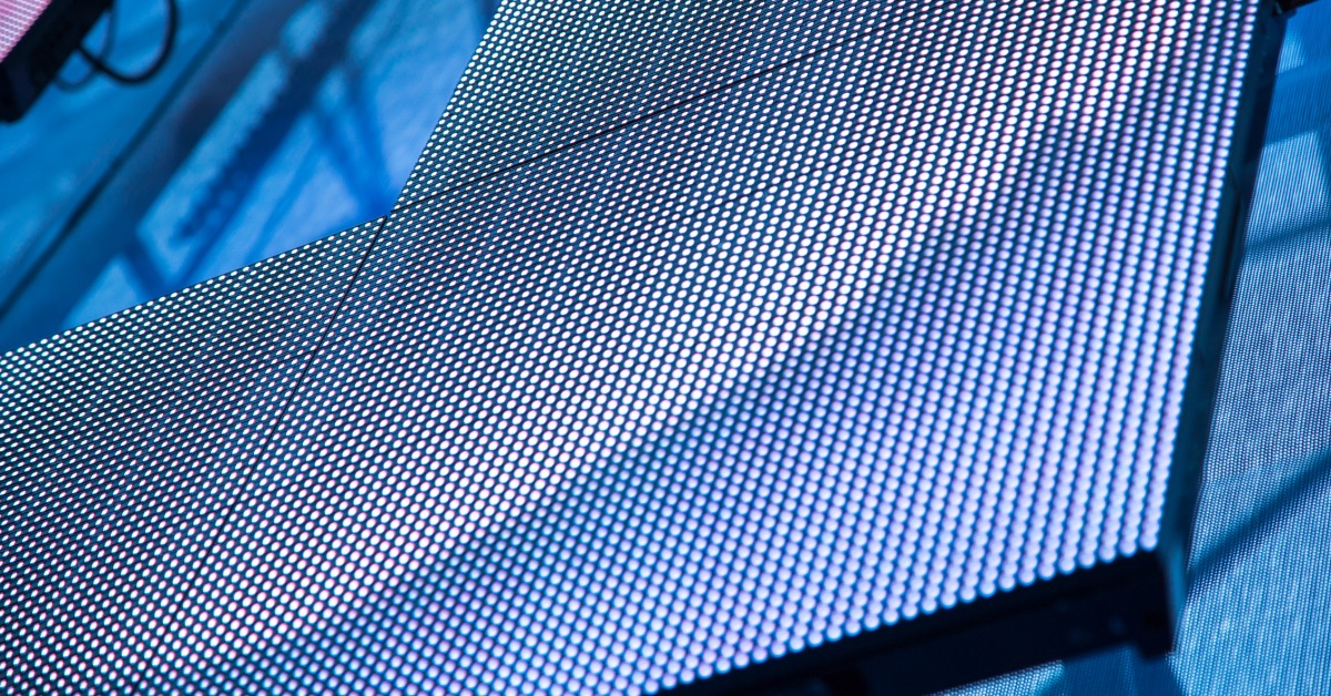 Close-up modular LED panels forming a dark grid of small square lights across a stage display surface.