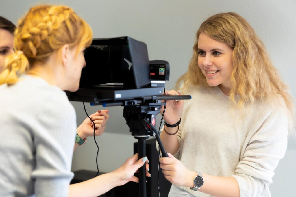 Two women checking the teleprompter for an executive run-through of Powerpoint.